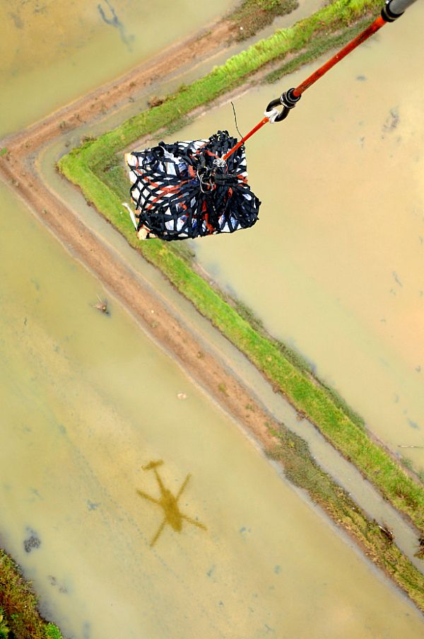 A HH-60H Seahawk helicopter from Helicopter Anti-Submarine Squadron (HS) 4 transports another pallet of bottled water from the deck of Military Sealift Command combat stores ship USNS Niagara Falls (T-AFS 3) for delivery to Kalibo, Republic of the Philippines. Kalibo is on the northern tip of Panay Island and was hit hard by the typhoon.