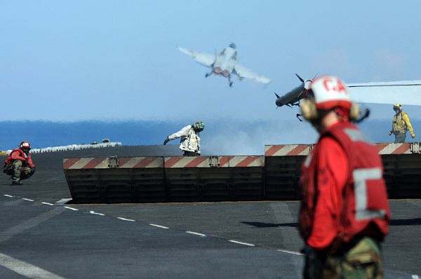As the jet blast deflectors retracts, flight deck personnel get ready to hook up the next aircraft on catapult 2, seconds after an F/A-18 jet is catapulted off the flight deck of the Nimitz-class aircraft carrier USS Ronald Reagan (CVN 76). As humanitarian efforts for the people of the Republic of the Philippines continued throughout the day, Ronald Reagan also conducted routine flight operations.