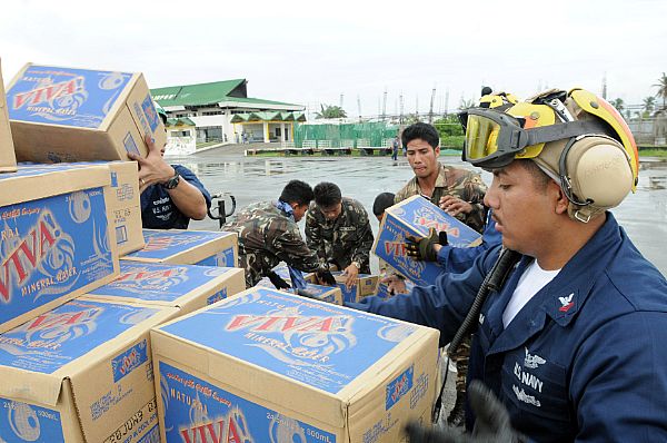 Aviation Boatswains Mate (Handler) 2nd Class William Sum unloads bottled water during relief efforts in wake of Typhoon Fengshen. Petty Officer Sum, a native of Panorama City, Calif., is assigned to USS Ronald Reagan (CVN 76) and is ashore at the Kalibo Airport directing U.S. helicopters arriving with supplies.