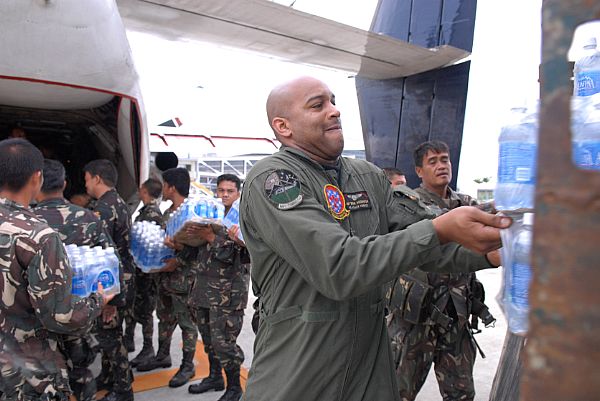 Aviation Warfare Systems Operator 1st Class Brian Anderson, of Spartanburg, S.C., helps service members assigned to the Philippine Army load a C-2A Greyhound with supplies from the Nimitz-class aircraft carrier USS Ronald Reagan (CVN 76) at Iloilo Airport. The supplies will be transferred to Kalibo Airport to be distributed to those in need after the wake of Typhoon Fengshen.
