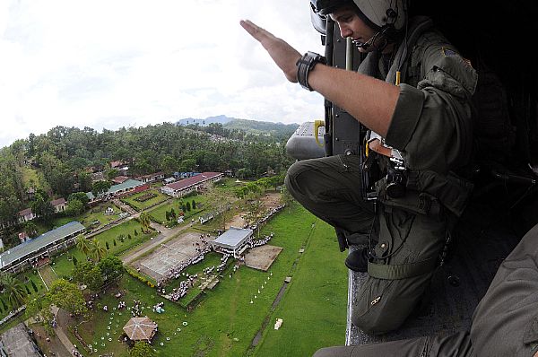 Aviation Warfare Systems Operator 2nd Class Travis Story, a native of Reading, Calif., waives goodbye to children at a school in the remote village of Altavas. Story is a helicopter pilot with the 