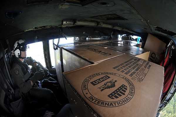 Aviation Warfare Systems Operator Slavek Glownia sits among relief supplies in the aft section of an SH-60F Seahawk helicopter assigned to Helicopter Anti-Submarine Squadron (HS) 4 during a humanitarian mission on the Philippine island of Panay. HS-4 is embarked aboard the aircraft carrier USS Ronald Reagan (CVN 76).