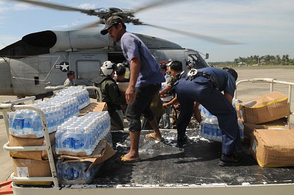 Bottles of water transported from the Nimitz-class aircraft carrier USS Ronald Reagan (CVN 76) are unloaded by Armed Forces of the Philippines (AFP), U.S. Navy personnel and civilians. The supplies will be distributed throughout devastated areas caused by Typhoon Fengshen.