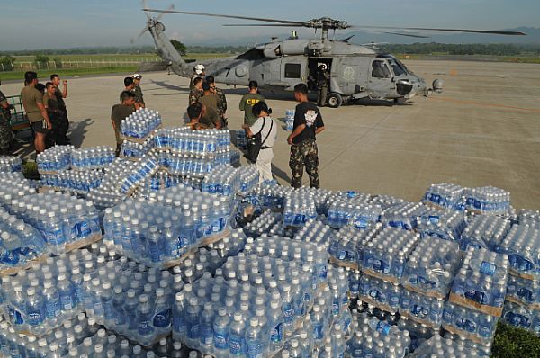 Bottles of water transported from the Nimitz-class aircraft carrier USS Ronald Reagan (CVN 76) wait to be delivered to devastated areas in the Republic of the Philippines caused by Typhoon Fengshen after Armed Forces of the Philippines (AFP) and U.S. Navy personnel unloaded it from an SH-60F Seahawk assigned to the 