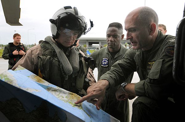 Capt. Thomas P. Lalor, right, deputy commander, Carrier Air Wing (CVW) 14, gives Lt. Ralph Silvas directions to the area he is to deliver humanitarian supplies to on Panay Island. Lalor is coordinating air operations for the Ronald Reagan Carrier Strike Group while they assist the Republic of the Philippines in the wake of Typhoon Fengshen.