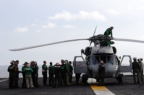 Flight deck personnel stand by as last minute maintenance is performed on an SH-60F Seahawk assigned to the 