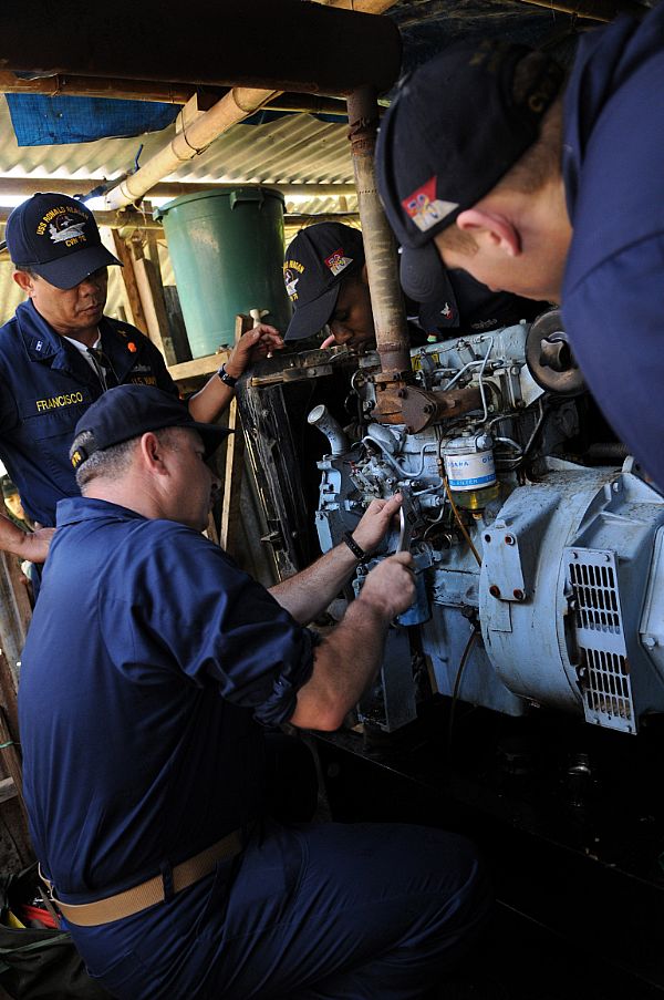 Master Chief Engineman Joseph Matteo, center, Chief Warrant Officer Zosimo Francisco, left, Electrician's Mate 2nd Class Dante Pine, and Engineman 2nd Class Shane Whittington troubleshoot a fuel pump on a generator at Barotac Viejo Regional Hospital in Iloilo. The Sailors, assigned to Engineering Department aboard the Nimitz-class aircraft carrier USS Ronald Reagan (CVN 76), have been inspecting, troubleshooting and repairing generators at hospitals in need of clean water and electricity after Typhoon Fengshen.