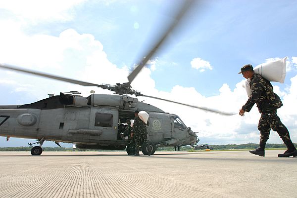 Members of the Armed Forces of the Phillipines (AFP) load an HH-60H Seahawk assigned to the 