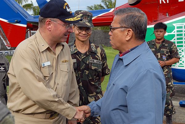 Rear Adm. James P. Wisecup, left, shakes hands with Angelo Reyes, Secretary of Energy for the Republic of the Philippines