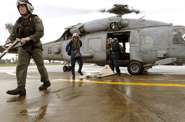 Sailors from the Ronald Reagan Carrier Group debark an HH-60H Seahawk assigned to Helicopter Anti-Submarine Squadron (HS) 4 while delivering bottled water to hard hit areas of the region following Typhoon Fengshen.