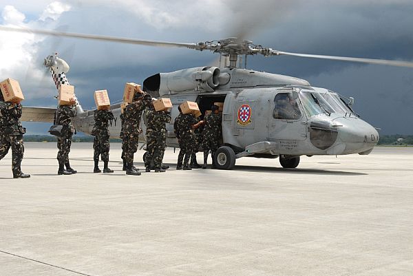 Service members assigned to the Philippine Army load an SH-60 Seahawk assigned to the 