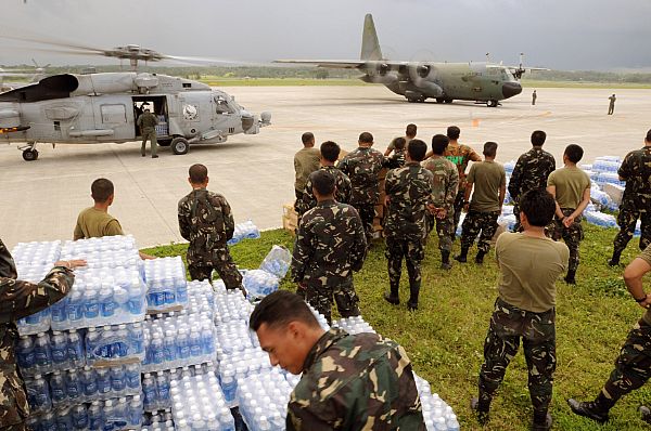 Servicemen of the Philippine Army stage themselves to transport bottled water to aircrafts assigned to the U.S. Navy and the Republic of the Philippines Air Force. The U.S. Navy and the Philippine Army and Air Force have been working side by side during disaster relief in the wake of Typhoon Fengshen.