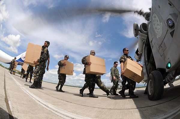 Soldiers with the Armed Forces of the Philippines aircrewmen assigned to Helicopter Anti-Submarine Squadron (HS) 4 load relief supplies onto an SH-60F Seahawk to air-lift to a remote location. HS-4 is embarked aboard the aircraft carrier USS Ronald Reagan (CVN 76).