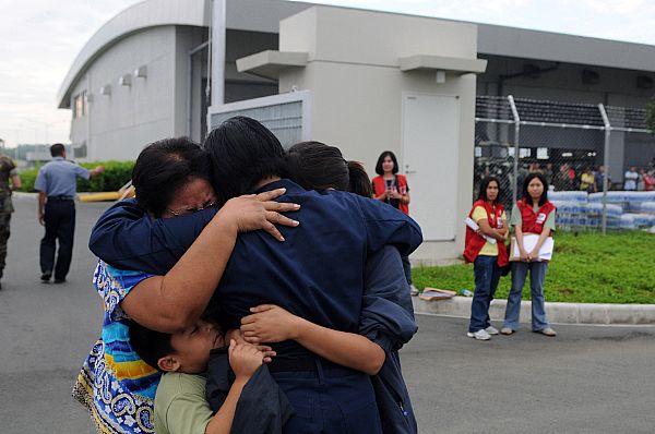 Storekeeper Seaman Grace Geroche, a native of Iloilo and Sailor assigned to the Nimitz-class aircraft carrier USS Ronald Reagan (CVN 76), embraces family members upon arriving as part of U.S. Navy relief operations. Her family nearly lost their lives in flooding caused by Typhoon Fengshen.