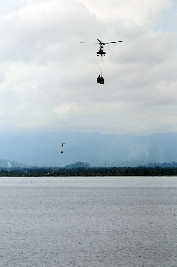 Super PUMA helicopters fly much needed bottled water to Kalibo, Republic of the Philippines from the deck of the Military Sealift Command combat stores ship USNS Niagara Falls (T-AFS 3) in the wake of Typhoon Fengshen.