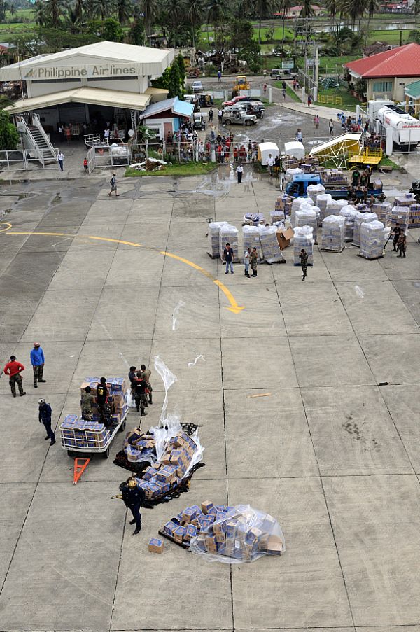 U.S. Navy and Philippine Army servicemen working together with their Philippine counterparts at the Kalibo Airport to get water and supplies to people affected by Typhoon Fengshen.